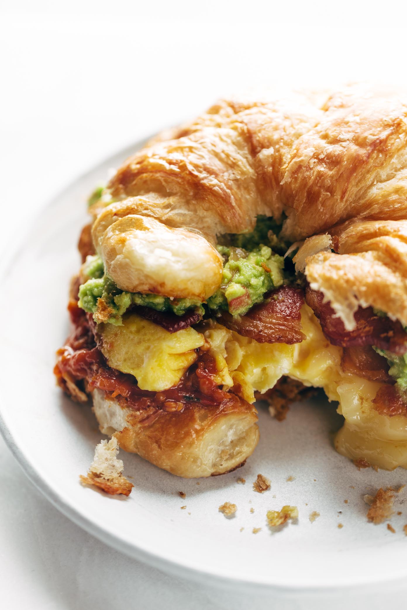 The Ultimate Breakfast Sandwich ??? with eggs, bacon, guacamole, chunky tomato sauce, pepper jack cheese, all on a toasted croissant. Favorite ever. | pinchofyum.com